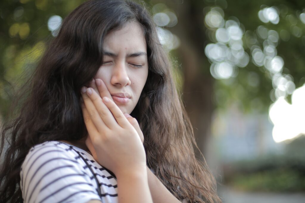 Woman holding her jaw because of tooth pain.