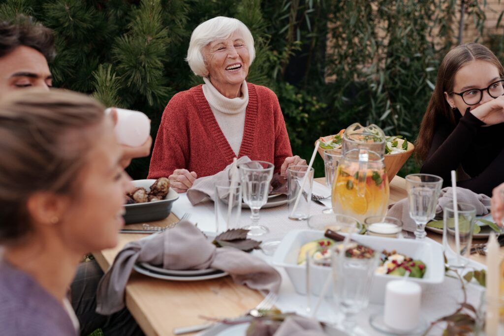 Older adult enjoying a meal with family after adjusting to dentures.